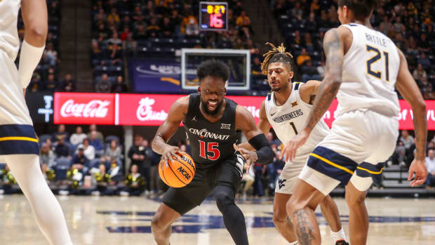 Jan 31, 2024; Morgantown, West Virginia, USA; Cincinnati Bearcats forward John Newman III (15) drives against West Virginia Mountaineers guard Noah Farrakhan (1) during the first half at WVU Coliseum. Mandatory Credit: Ben Queen-USA TODAY Sports